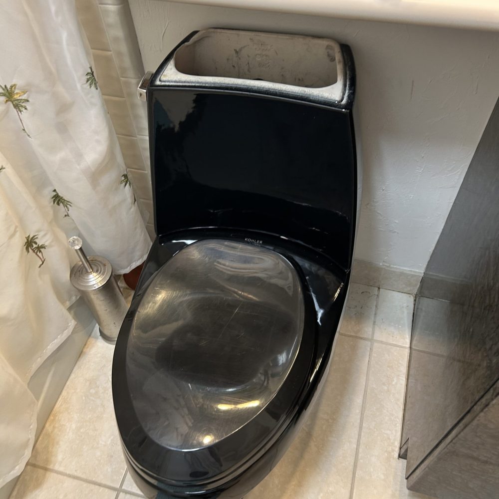 Residential bathroom toilet and surrounding plumbing installation area.